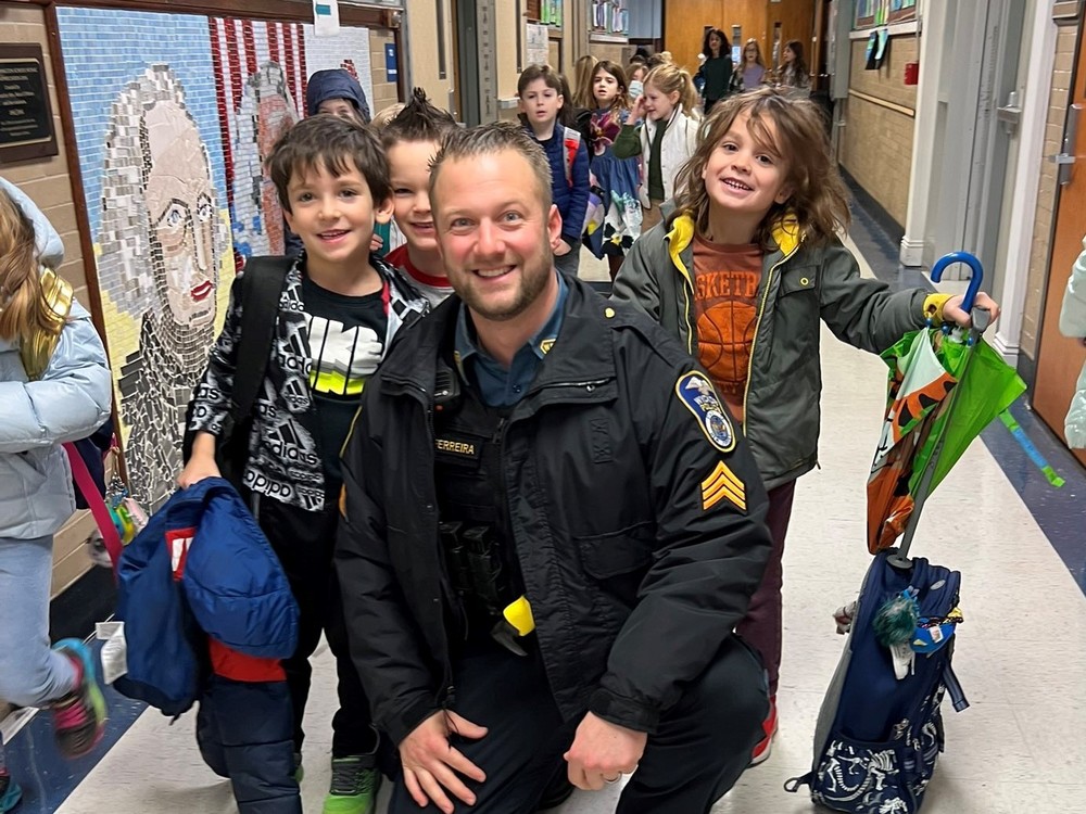 Policeman and students smiling in hall