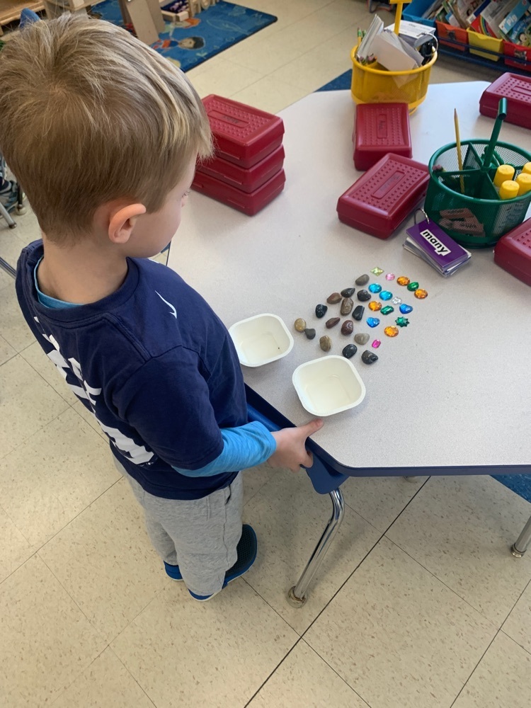 boy arranging loose parts on a table
